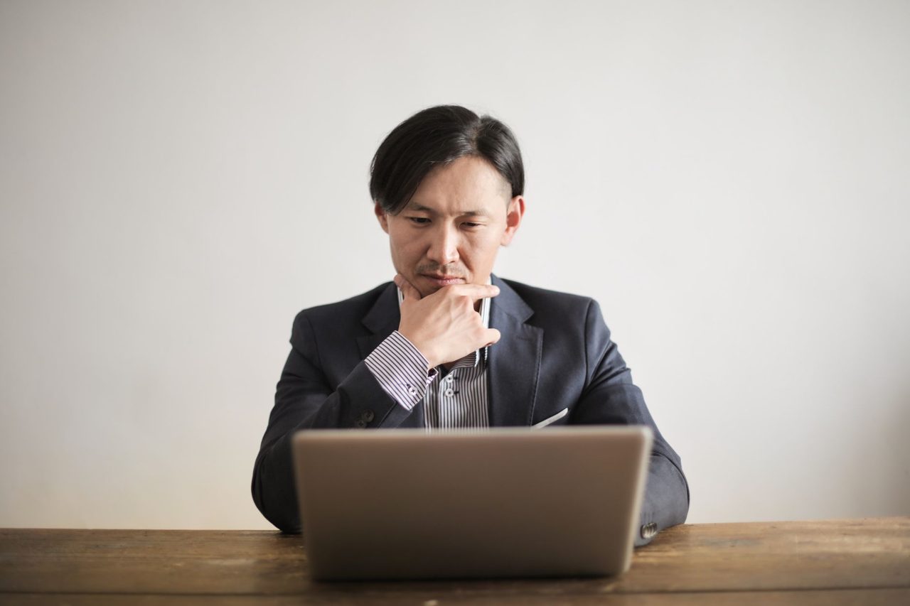 ノートPCでAIツールを比較検討するビジネスパーソン